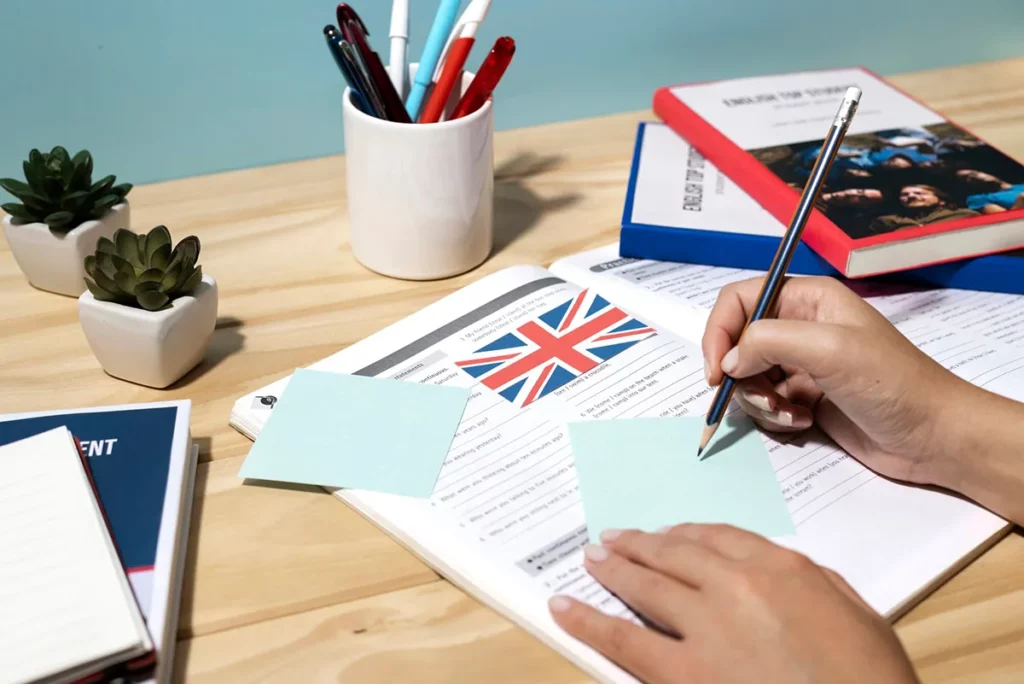 студент се припрема за IELTS и фаќа забелешки врз учебник по англиски јазик