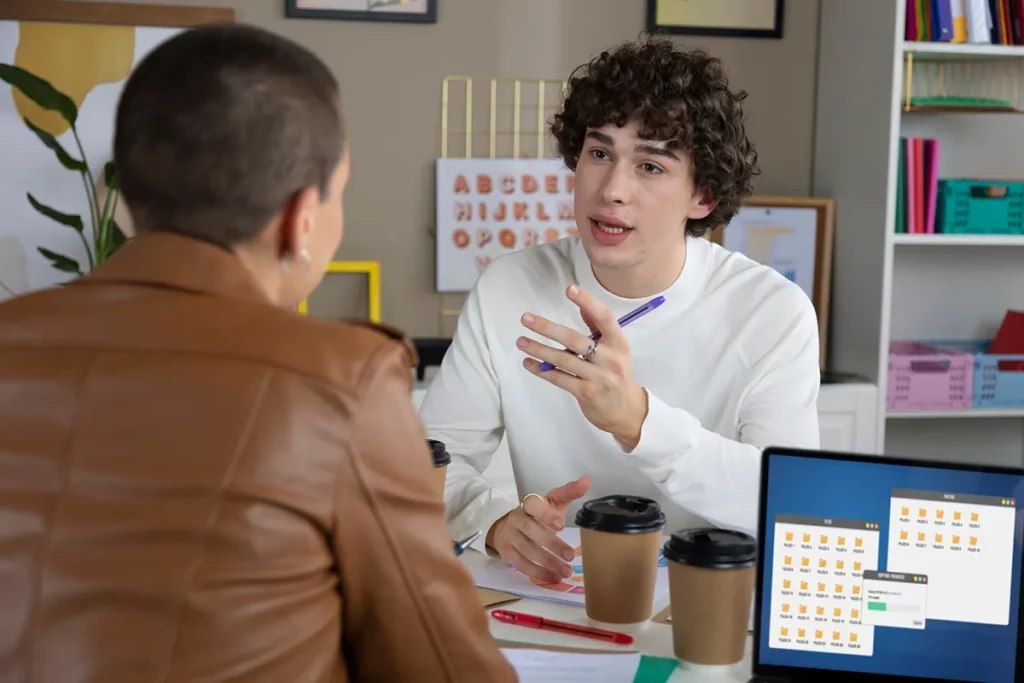 професор во разговор со студент кој се спрема за TOEFL